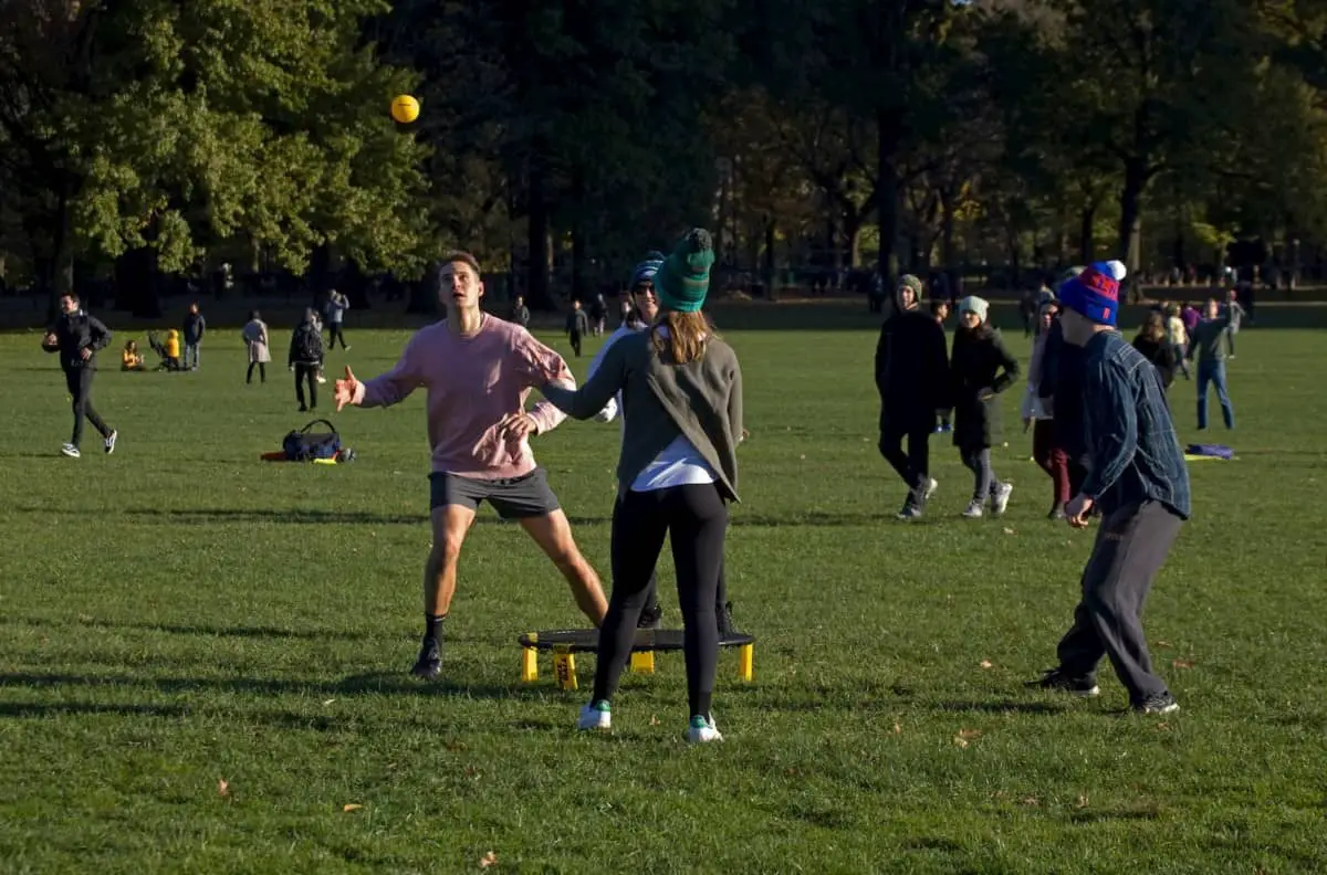 Guys playing spikeball in a park on grass - What is the Difference Between Spikeball and Spikeball Pro